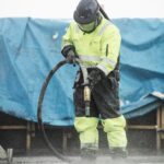 Trockeneisstrahlen vs Sandstrahlen – Profi beim Strahlen mit Schutzausrüstung